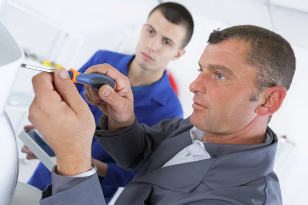 Elektryk i mężczyzna ucznia nauczyć używać śrubokręta — Zdjęcie stockowe