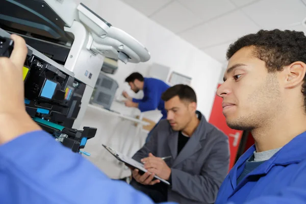 Jeune technicien masculin réparer photocopieuse numérique — Photo