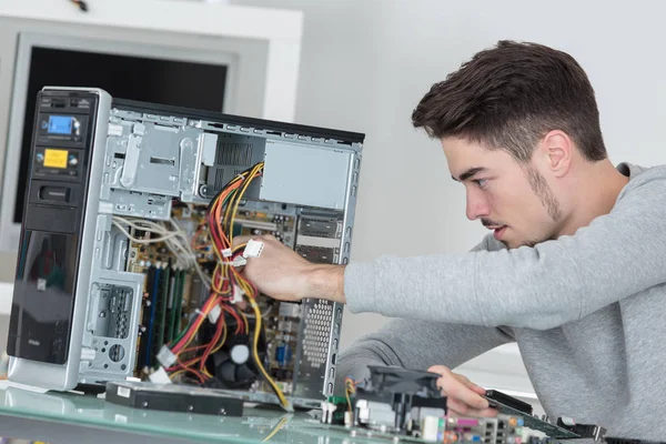 Hombre trabajando en una computadora rota — Foto de Stock