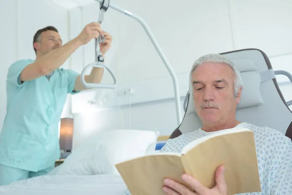 Νοσοκόμα προσαρμογή κυματίζει, ασθενής διαβάζοντας το βιβλίο — Φωτογραφία Αρχείου