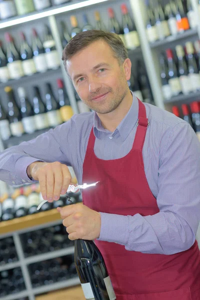 Sommelier abrindo garrafa de vinho na adega — Fotografia de Stock