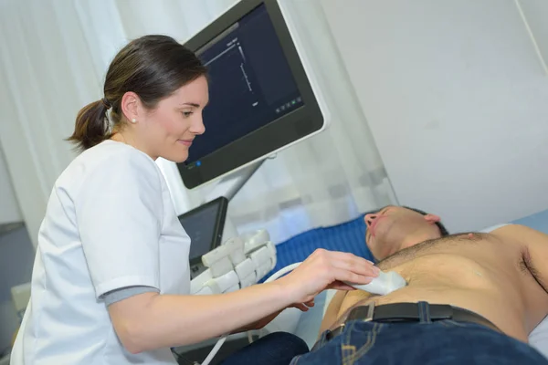 Médico realizando ultrasonido en el abdomen del hombre — Foto de Stock