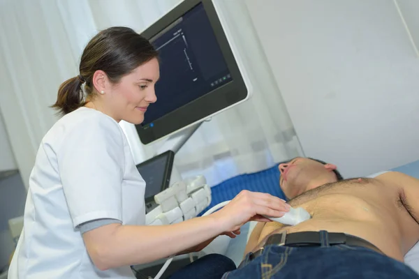 Médico realizando ultra-som no abdômen do homem — Fotografia de Stock