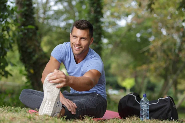 Man stretches the body before running — Stock Photo, Image