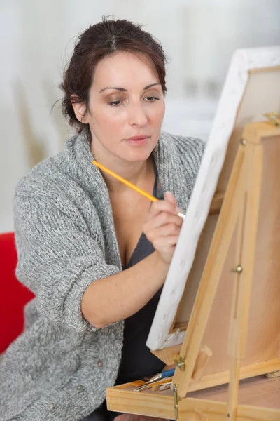 Dibujo del pintor femenino en el estudio de arte usando caballete —  Fotos de Stock