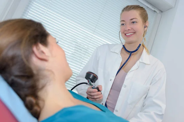 Жінка-лікар приймає красиві жінки кров'яний тиск — стокове фото