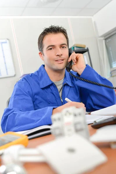 Eletricista ao telefone para um cliente — Fotografia de Stock