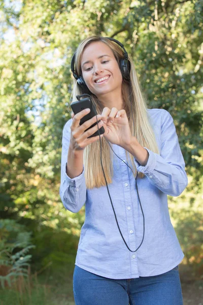 Ormanın içinde müzik dinlerken kadın runner gülümsüyor — Stok fotoğraf