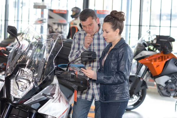 Couple heureux cherchant à acheter une moto — Photo