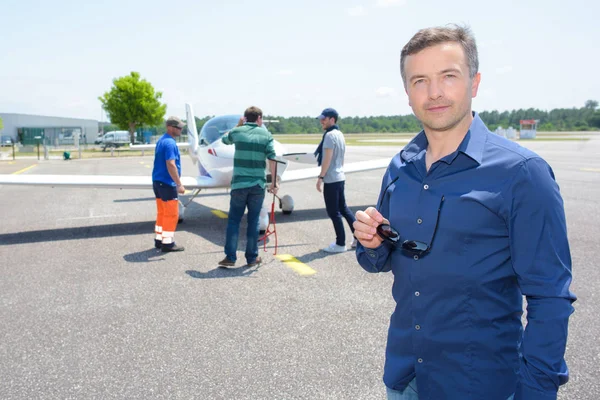 Portret van man in de luchthaven, technici zijn vliegtuig controleren — Stockfoto