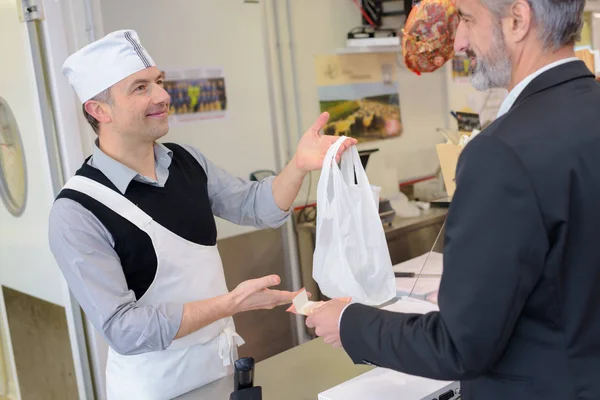 肉屋の店で店員とクライアントの作業 — ストック写真