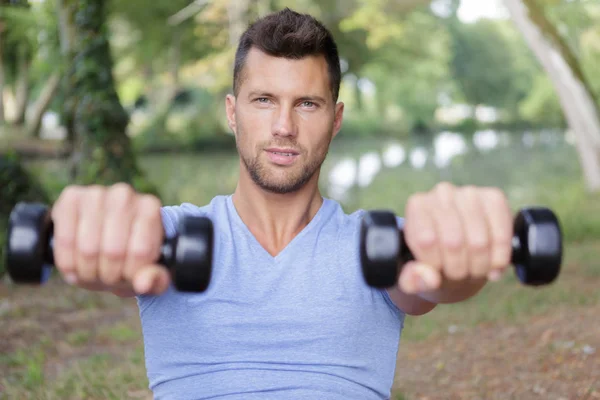 Musculoso masculino desportista formação com halteres — Fotografia de Stock