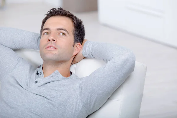 Jovem bonito homem relaxante no sofá deitado e sonhando — Fotografia de Stock