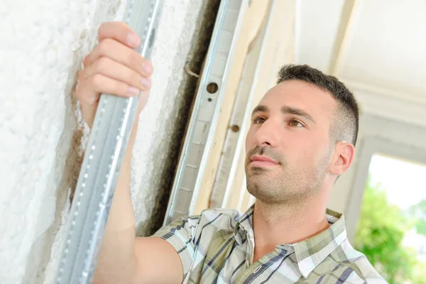 Bauarbeiter im Haus hält Metallgerüst — Stockfoto