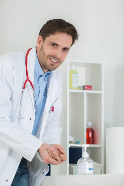 Arts met behulp van sanitizer dispenser in kliniek — Stockfoto