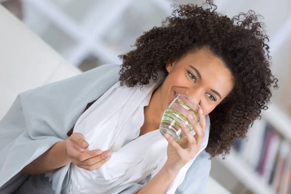 Vrouw houdt in handen pillen en glas water — Stockfoto