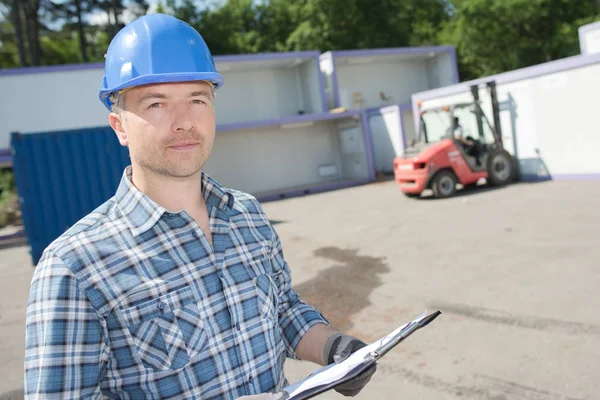 Mann im Hof hält Klemmbrett — Stockfoto