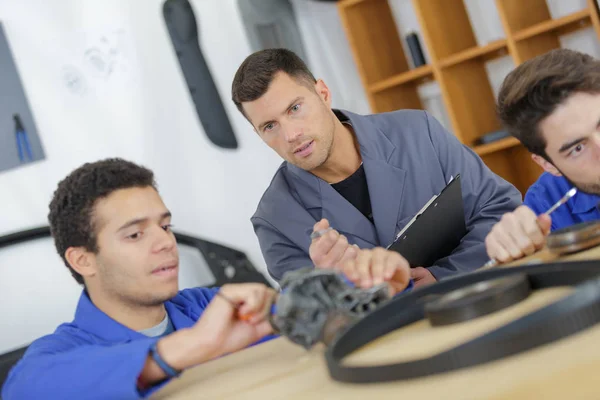 Man explaining mechanic pieces to trainee — Stock Photo, Image