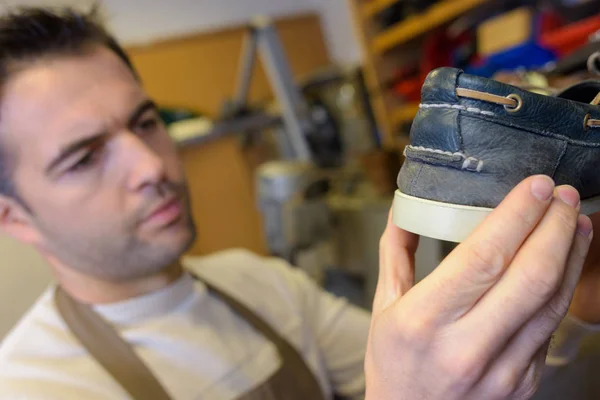 Cobbler sosteniendo un zapato de cubierta — Foto de Stock