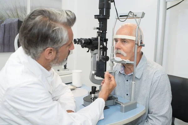 Masculino sênior no olho clínica examinar os olhos — Fotografia de Stock