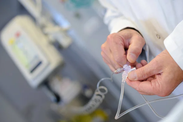 Trabalhador médico ajustando dosagem de gotejamento — Fotografia de Stock