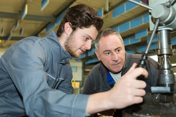 Aprendiz obrero de fábrica aprendiendo el oficio con el mentor —  Fotos de Stock