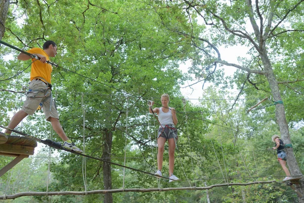 Famiglia su una corda arrampicata nel parco avventura — Foto Stock