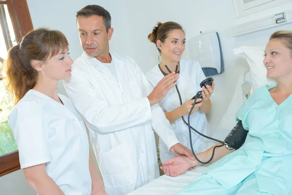 Médico demostrando cómo tomar la presión arterial — Foto de Stock