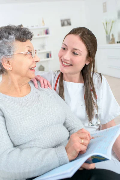 Professionella kvinnliga läkare undersöka äldre kvinna hemma — Stockfoto