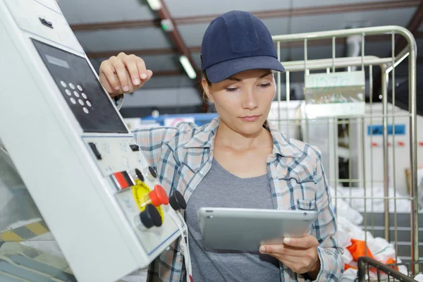 Kvinnlig arbetstagare använder digitala surfplatta inom tillverkningsindustrin — Stockfoto