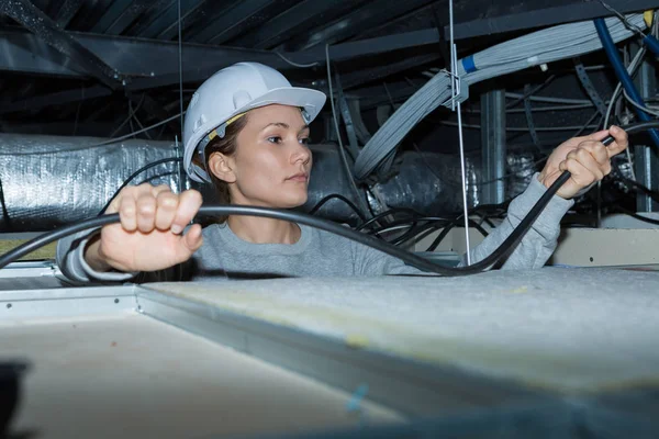 Eletricista feminino reparar fiação teto — Fotografia de Stock