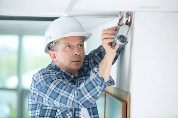 Técnico senior ajuste de la cámara de cctv en la pared — Foto de Stock