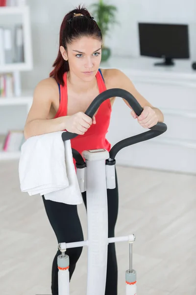 Addestramento sportivo della donna sulla macchina passo passo nel luminoso soggiorno — Foto Stock