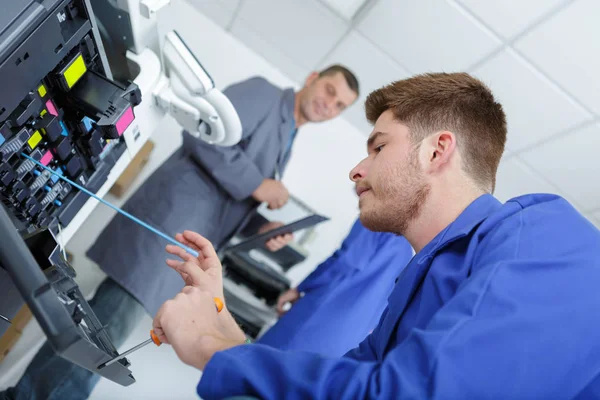 Portret van jonge man door drukmachine — Stockfoto