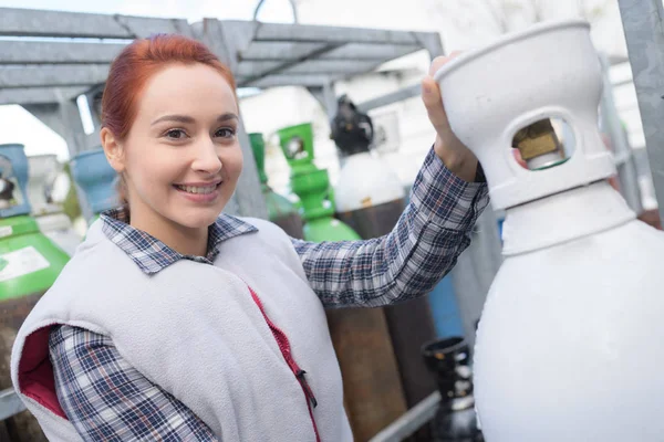 Werkneemster met met gasflessen — Stockfoto