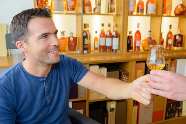 Mannen provsmakning cognac i spirit store — Stockfoto