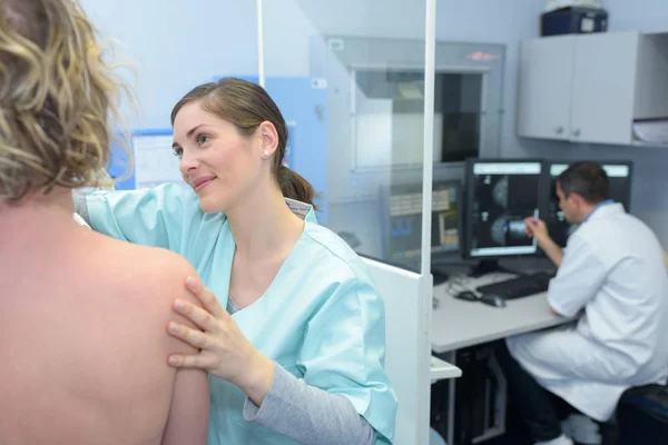 Szép női orvos a beteg beállítása a megfelelő pozícióban — Stock Fotó