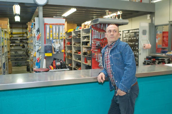 Uomo in attesa di assistenza presso un bancone di un negozio — Foto Stock