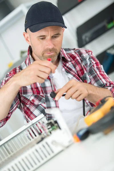 Techniker hält den digitalen Spannungszähler in der Hand — Stockfoto