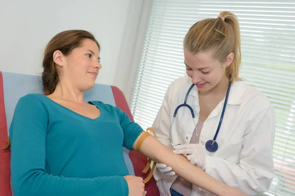 Verpleegkundige zoeken ader in de arm van de vrouw — Stockfoto