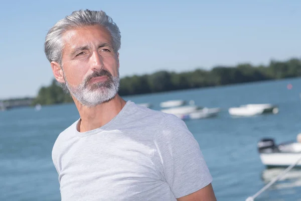 Schöner Mann posiert vor Segelbooten und See — Stockfoto