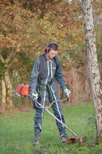 Les hommes font face à couper l'herbe couper l'herbe — Photo