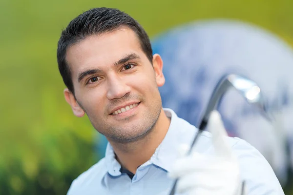 Sorrindo jogador de golfe em pé no campo — Fotografia de Stock