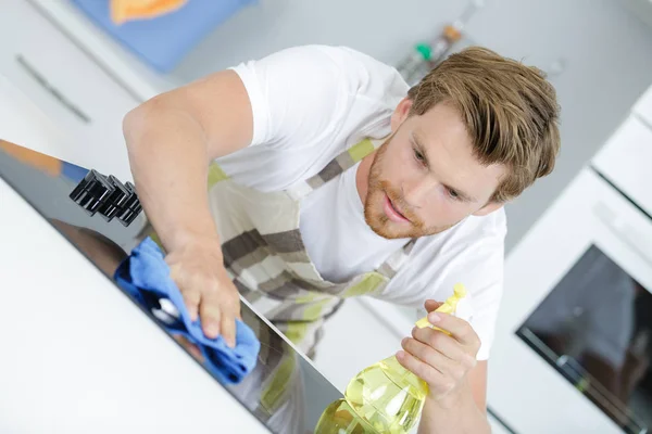 Inserviente maschio pulizia cucina contatore con detergente spray — Foto Stock