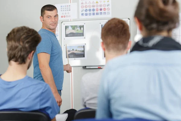 Instrutor de condução e estudantes motoristas em uma classe — Fotografia de Stock