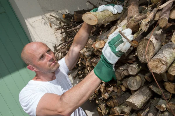 Homem tomando logs de pilha — Fotografia de Stock