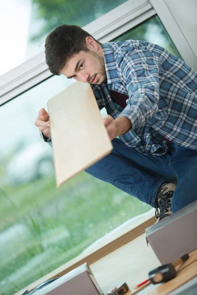 Snickare använda linjalen för att mäta trä ombord — Stockfoto