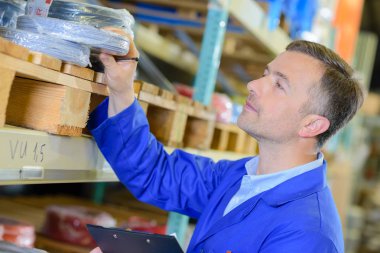 Man taking roll of cable from shelf clipart