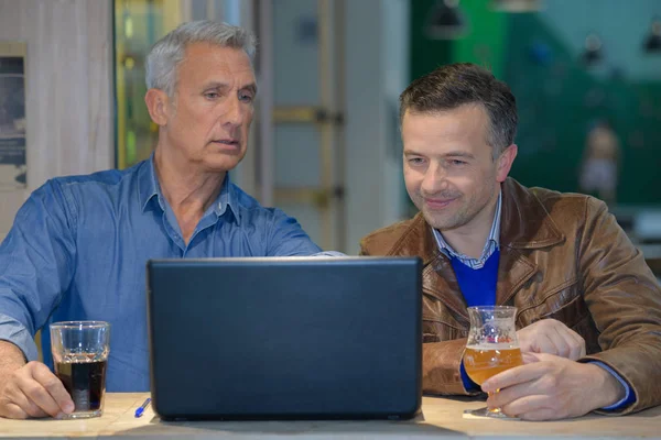 Hombre de negocios mostrando la información de su compañero de trabajo en una computadora —  Fotos de Stock