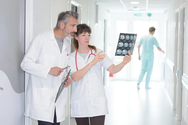 Medico donna e collega di lavoro guardando i raggi X — Foto Stock